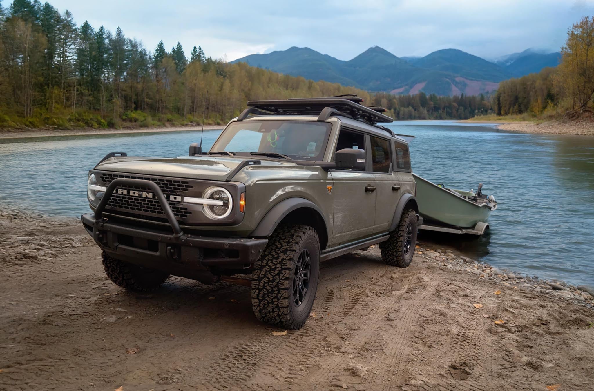 2026 Ford Bronco pulling a boat trailer out of a lake near a tree lined shore