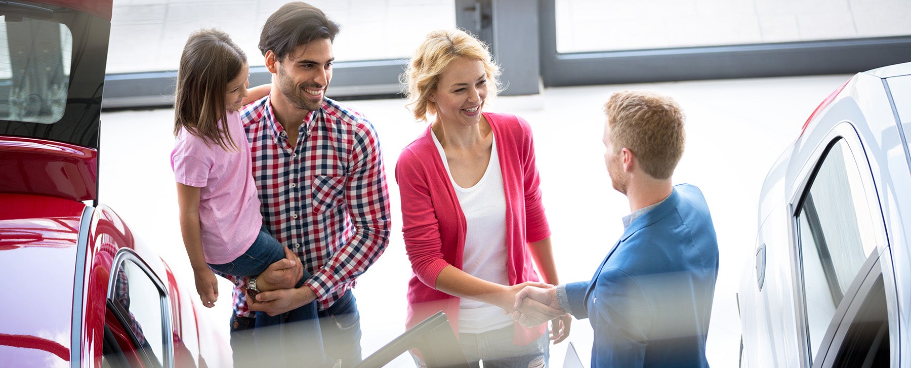 a family at a dealership going over financial information.